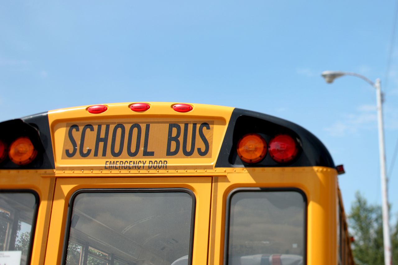 A bus is park on street outside of school. Generic image of a school busCredit: Getty