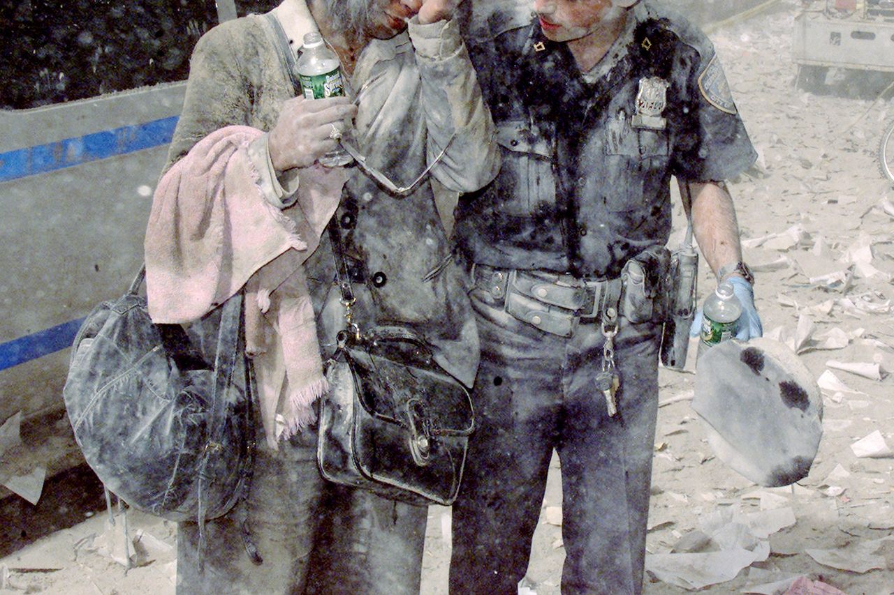 A police officer helps a distraught woman, as ash and debris cover the area following the collapse of 1 World Trade Center. Officer Mike Brennan helps a woman known only as Beverly, as ash and debris cover the area following the collapse of 1 World Trade CenterCredit: Corey Sipkin/NY Daily News Archive via Getty