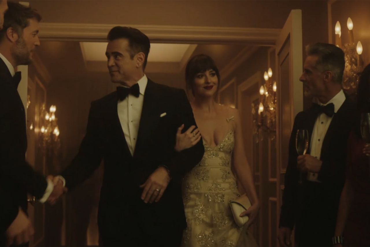 Dakota Johnson standing with a group of formally dressed people in a luxurious setting Colin Farrell and Dakota JohnsonCredit: CBS