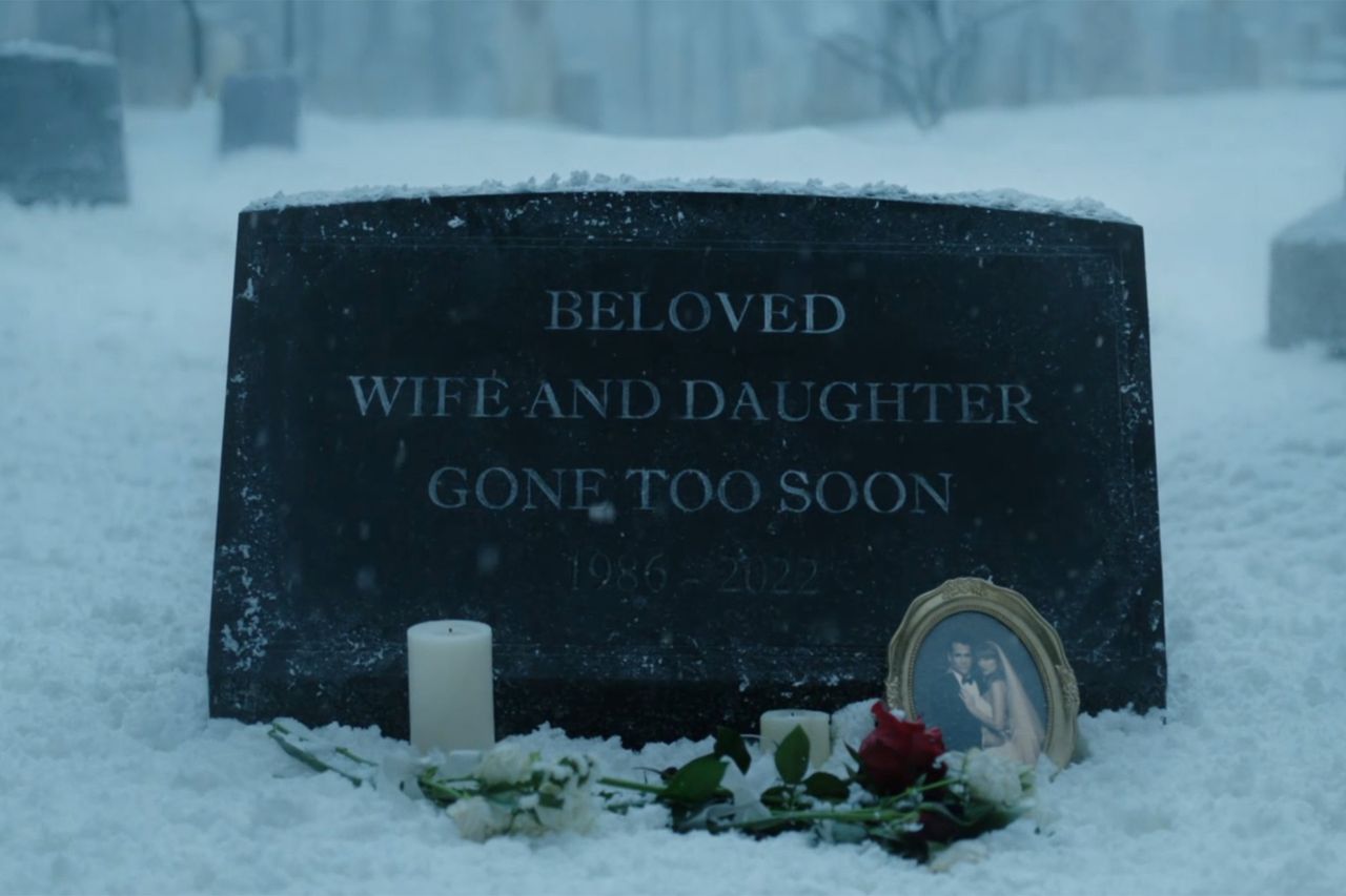 A gravestone in a snowy setting with memorial items in front including candles and a photo Taylor Swift’s fictional grave in “Patient Zero”Credit: CBS